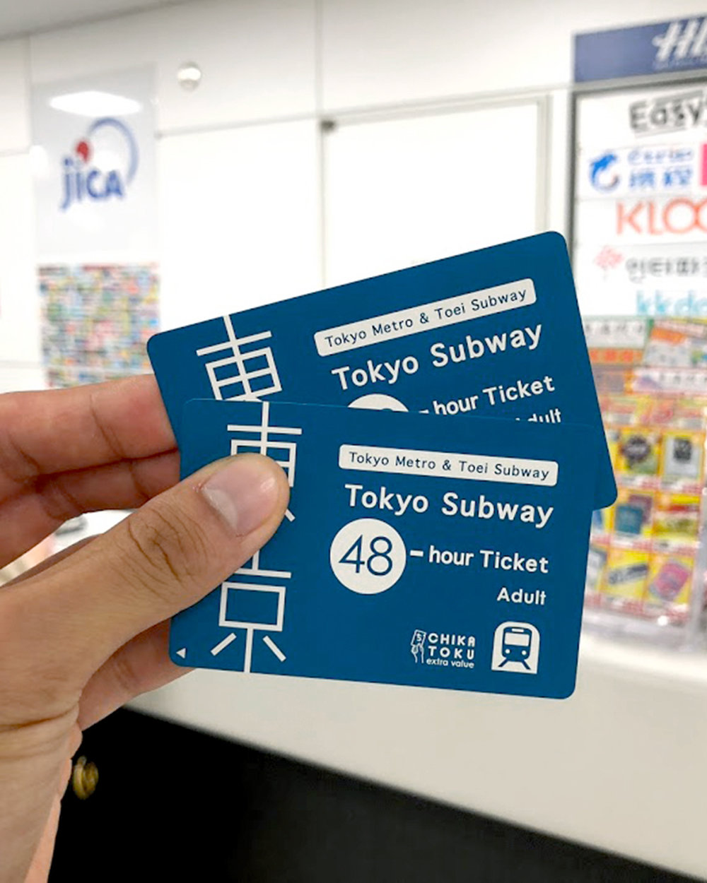 Tokyo Metro subway pass tickets held by a traveler