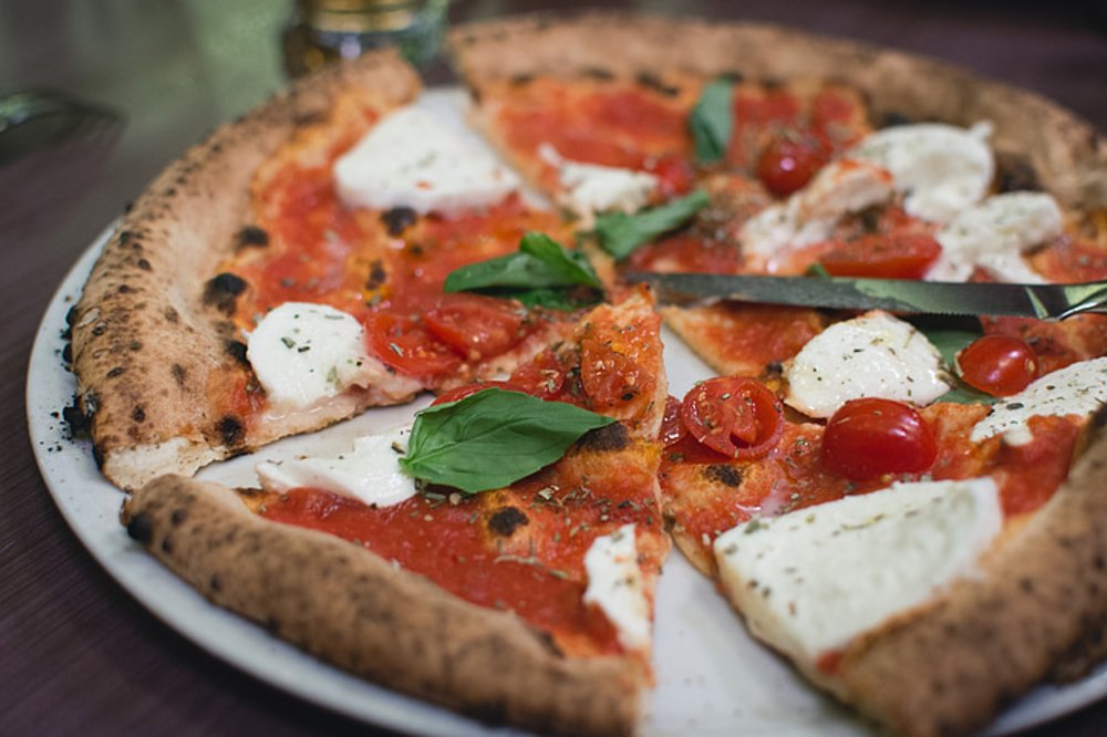 A whole margherita pizza, sliced