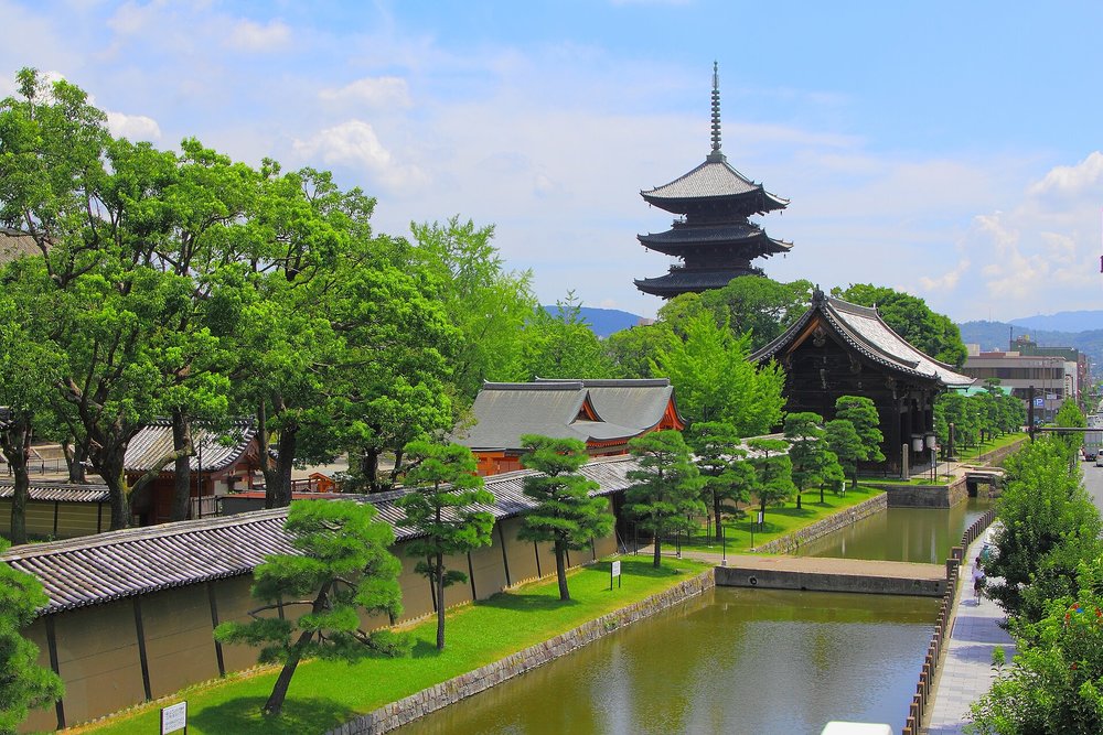 Five-story pagoda of To-ji Temple reflected near canal and gardens in Kyoto, Japan
