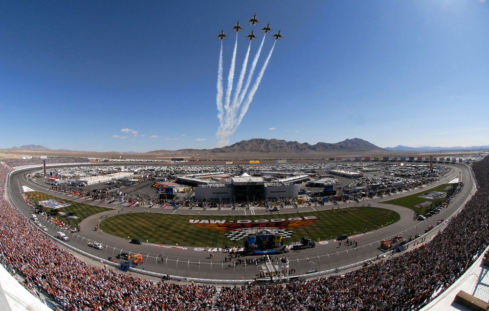Aerial view of NASCAR race at Las Vegas Motor Speedway with crowd-filled grandstands 
