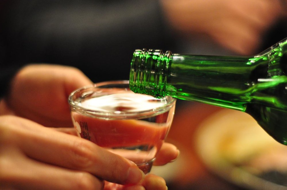 Korean soju being poured into a shot glass