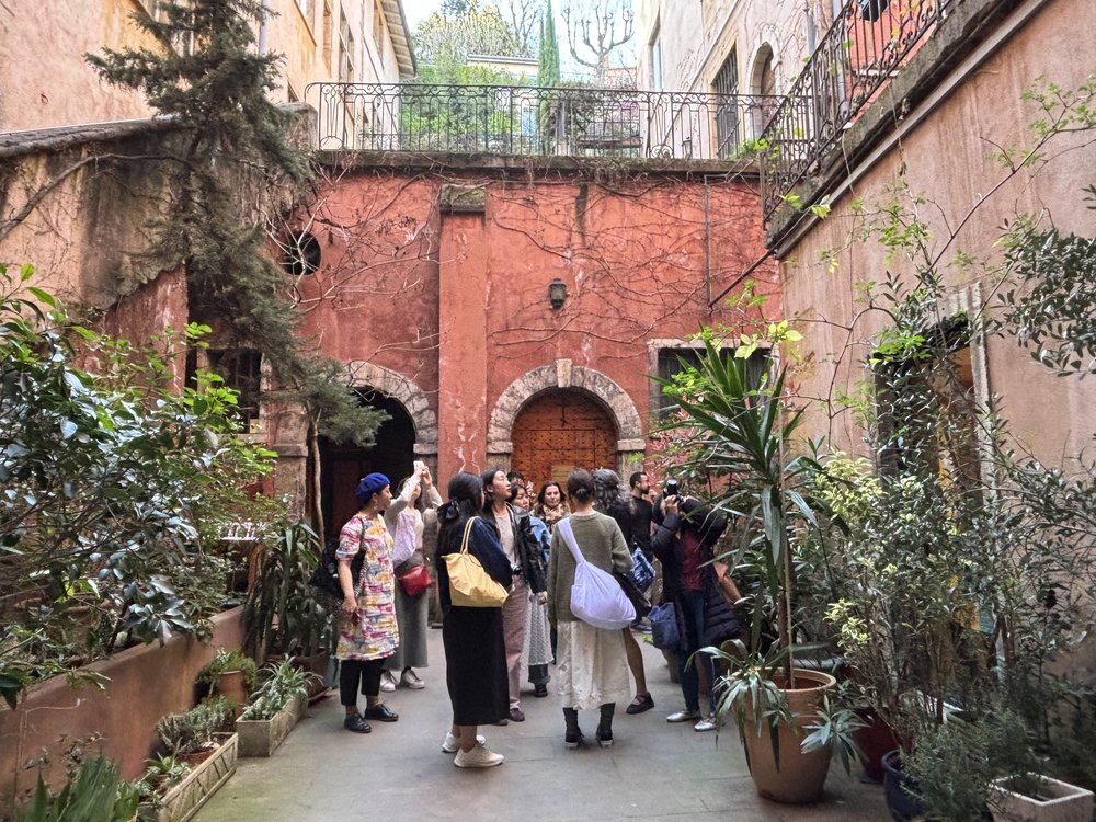 Visitors exploring hidden courtyard in Lyon Old Town traboules