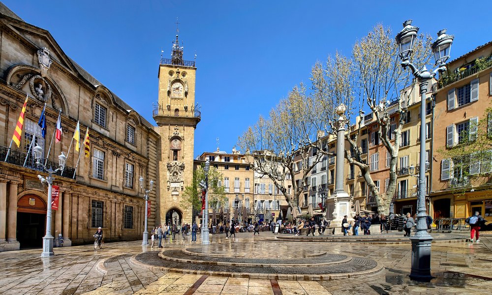 Sunny Provence town square with historic buildings and lively cafés