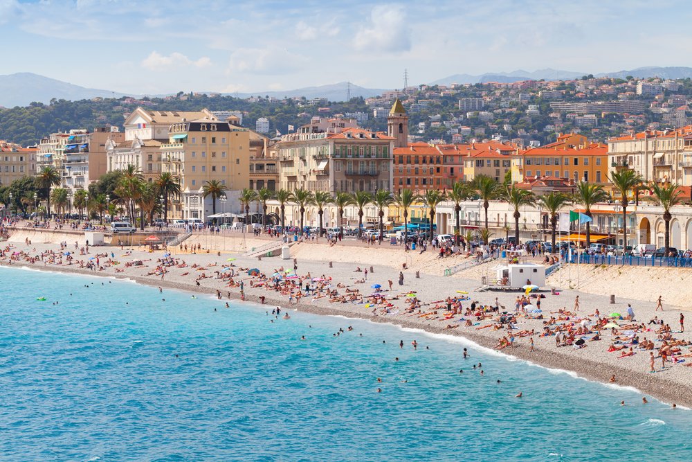 Nice beach and Promenade des Anglais with colorful buildings and clear blue sea
