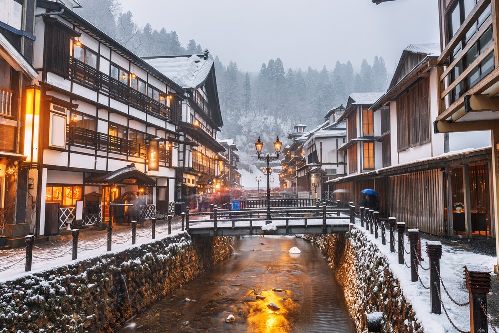 Ginzan Onsen winter street with snow, traditional inns, and lantern lights