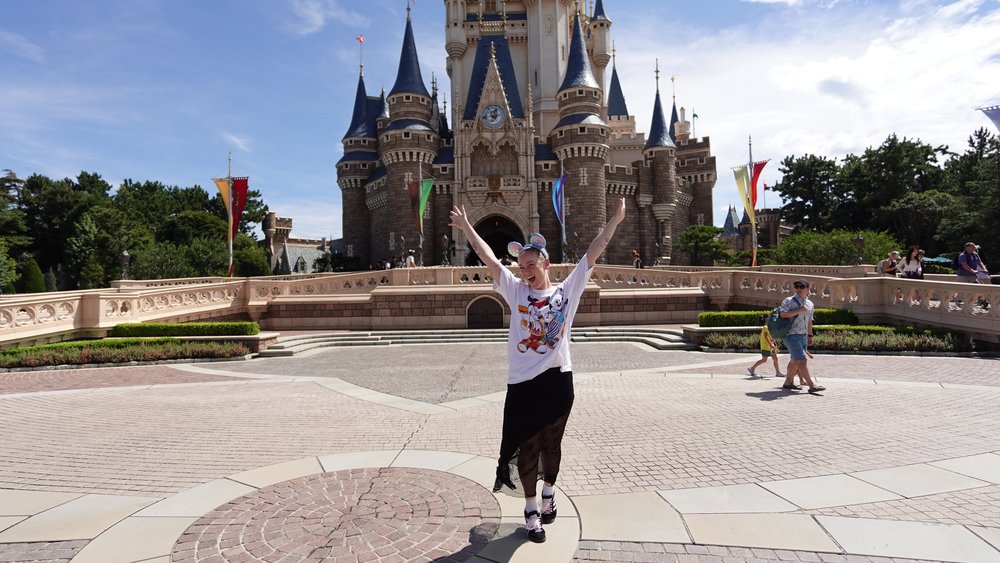 Tokyo Disneyland castle with guest posing in front