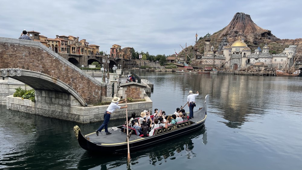 Gondola boat ride at Tokyo DisneySea with themed harbour and volcano backdrop