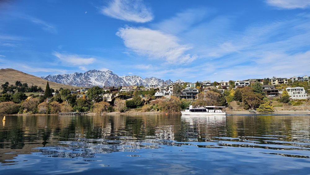 Lake Wakatipu Queenstown view with mountains, lake reflections, and waterfront houses
