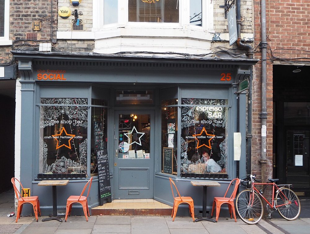 Front view of Fossgate Social with outdoor seating, signage, and a bicycle parked nearby
