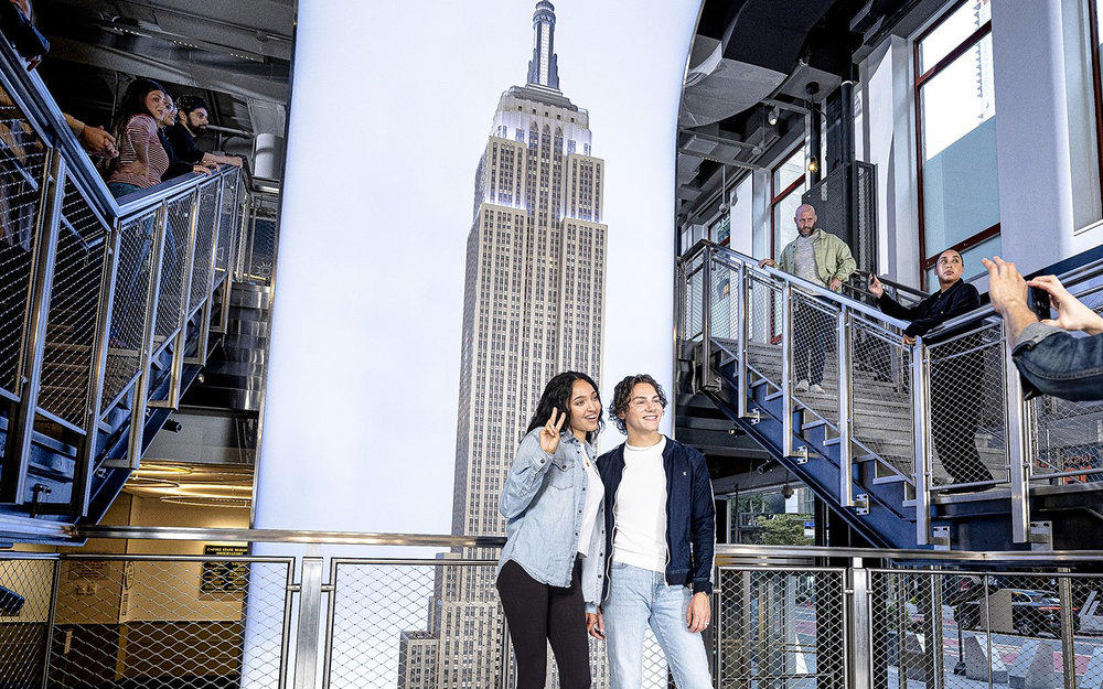 Tourists inside Empire State Building observation deck with city views