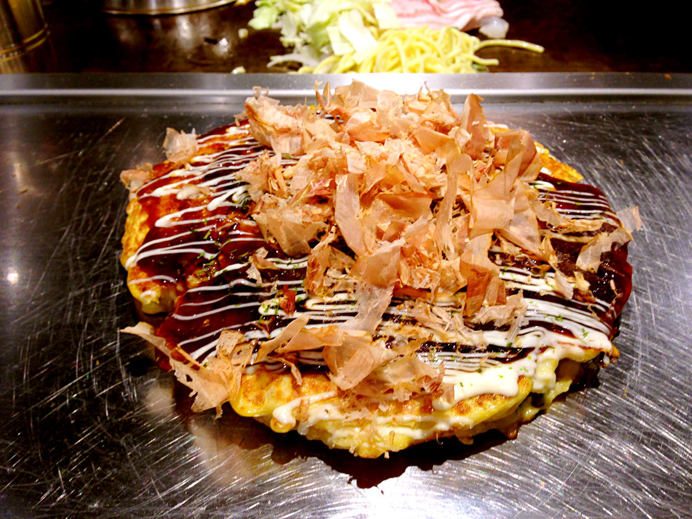 Osaka-style okonomiyaki savory pancake on a teppan grill | Photo from Zheng Zhou on Wikimedia Commons