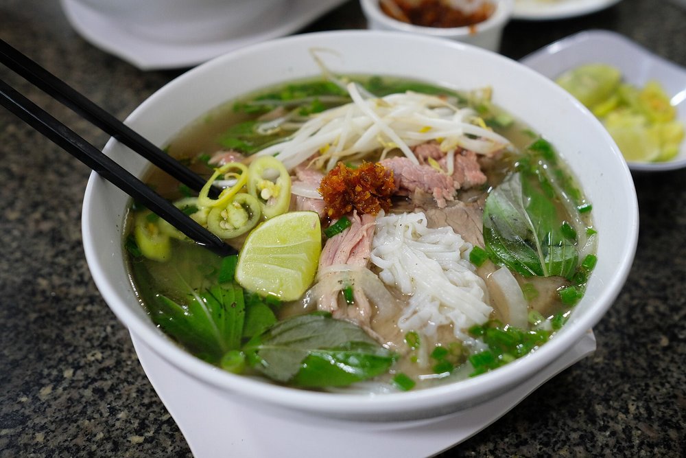 Traditional pho in Vietnam with herbs, lime, and beef noodles | Photo from Vinnie Carabiano on Wikimedia Commons