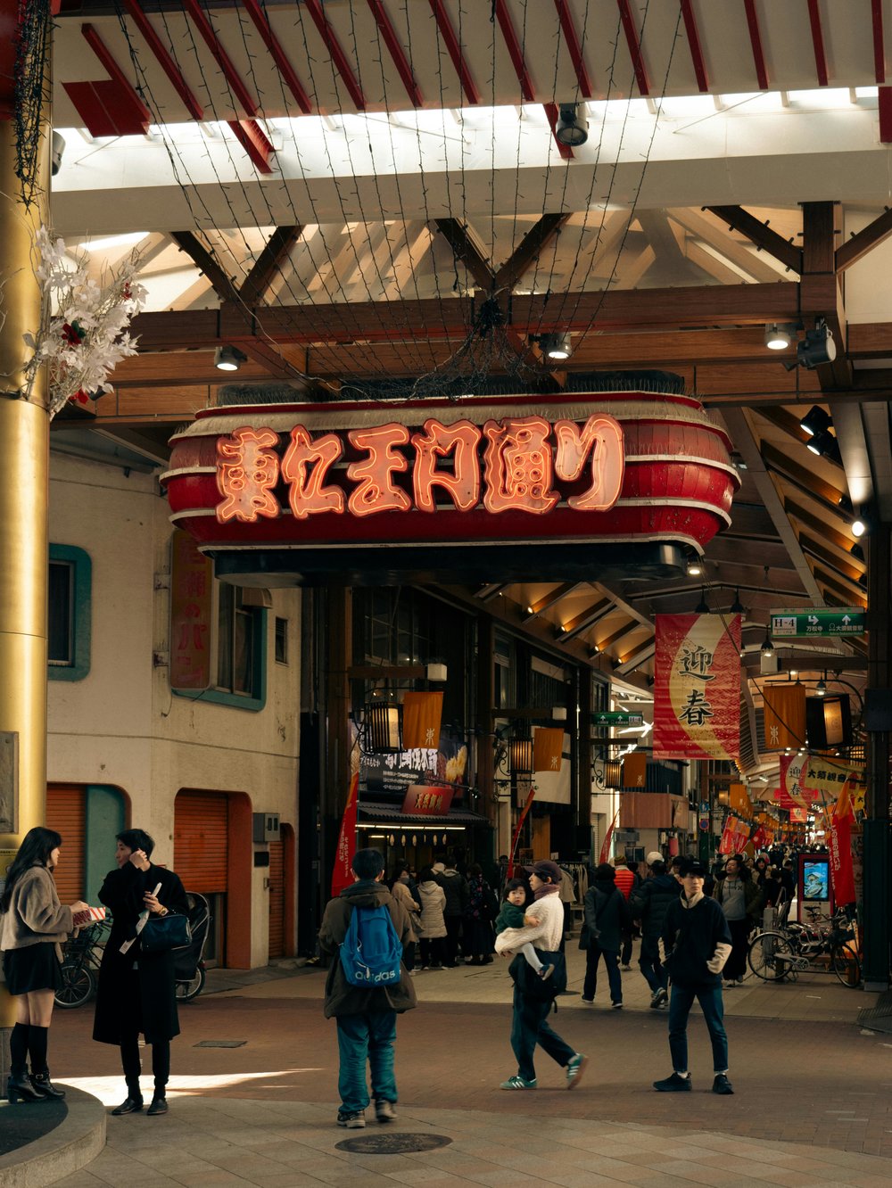 People standing by the Osu Shopping District signage