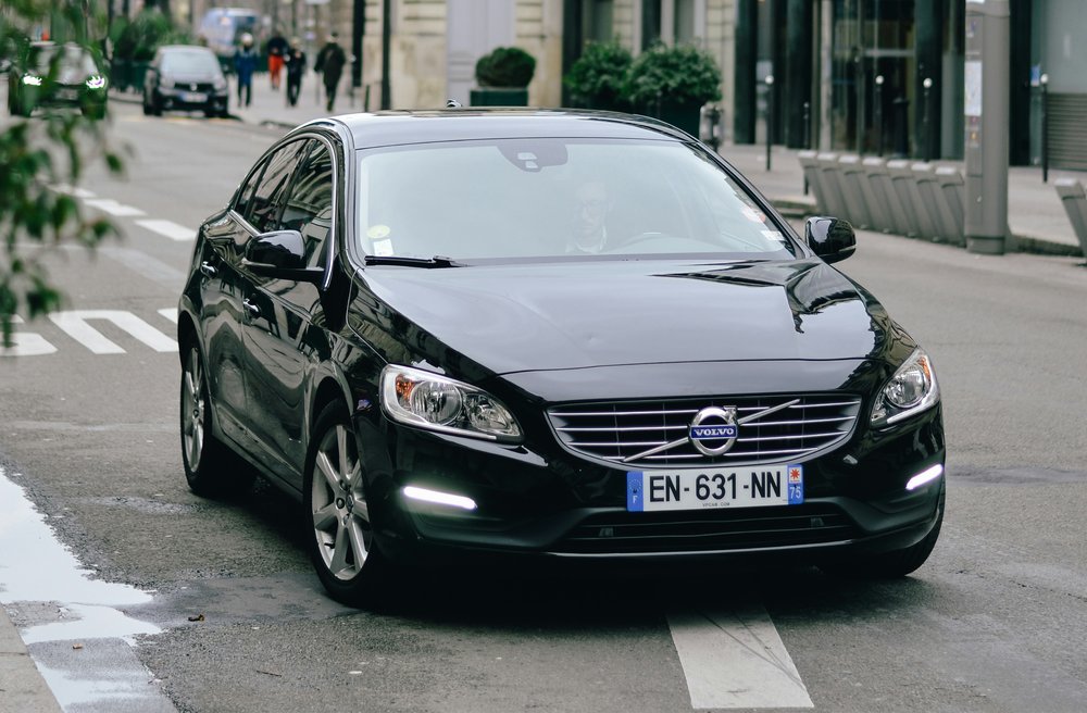 A black sedan on the road in the daytime