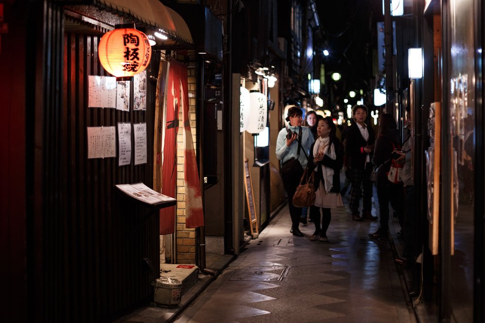 People walking along a narrow alley in the evening