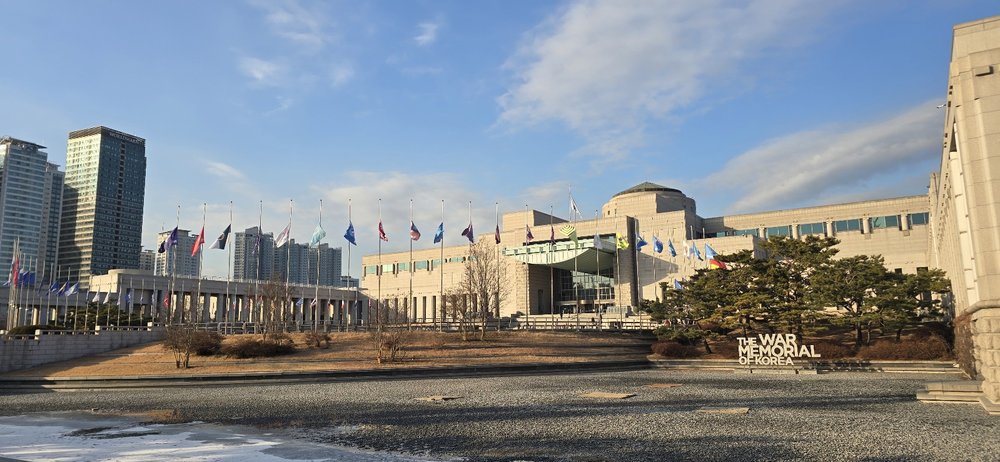 Wide view of the War Memorial of Korea building with flags and open plaza in Seoul