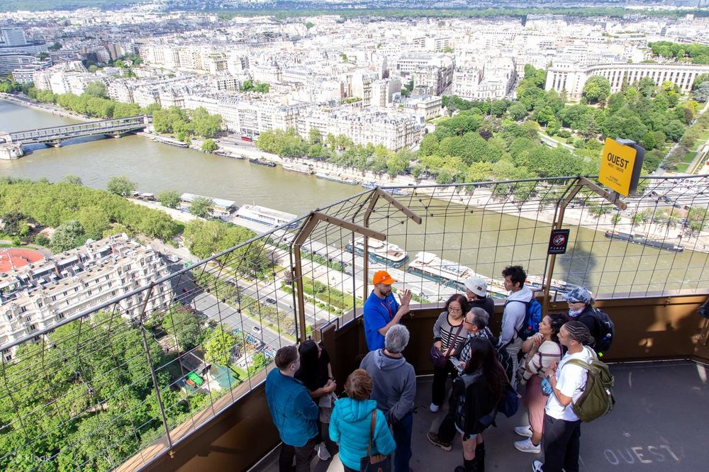 A group of people on the edge of the Eiffel Tower