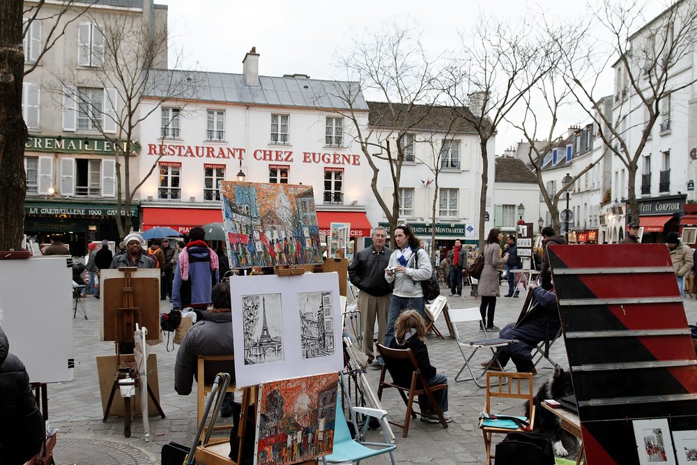 Easels with artworks surround the square