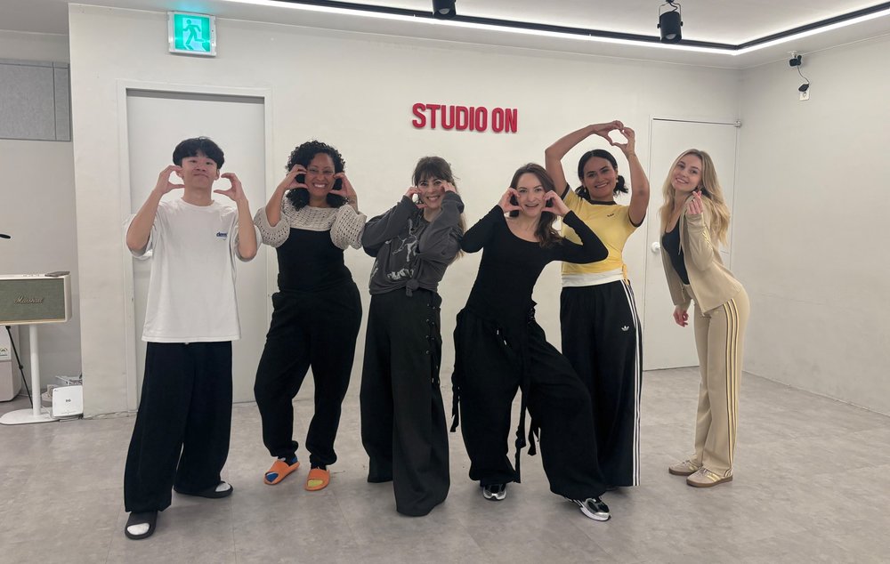 K-pop dance class participants posing together in Seoul studio