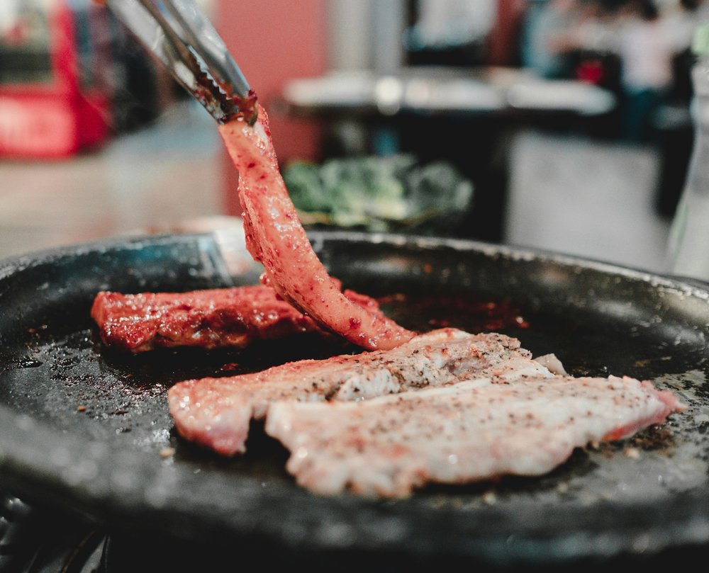 Pork belly being grilled at a Korean restaurant.