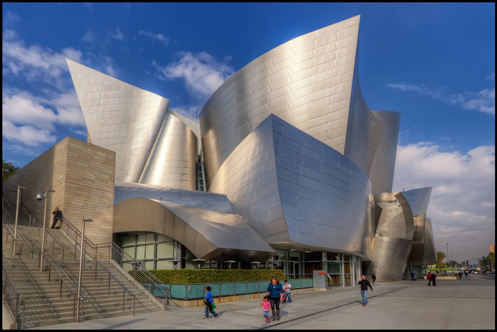 The Walt Disney Concert Hall with its shiny curved steel panels and people walking nearby