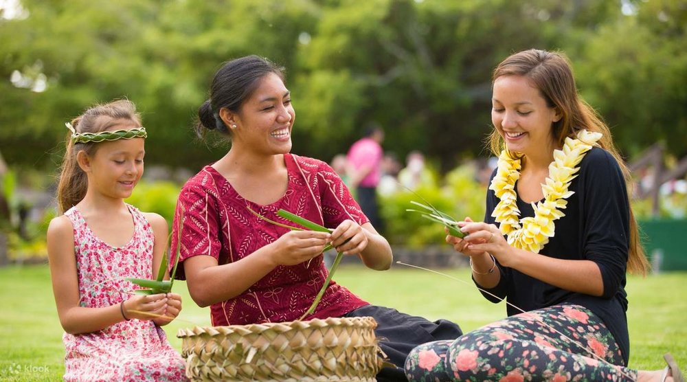 Tourists and locals weaving leaves together