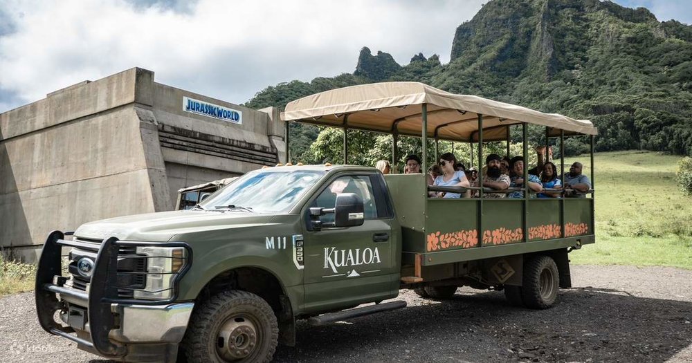 A group of tourists posing by the Jurassic World set piece