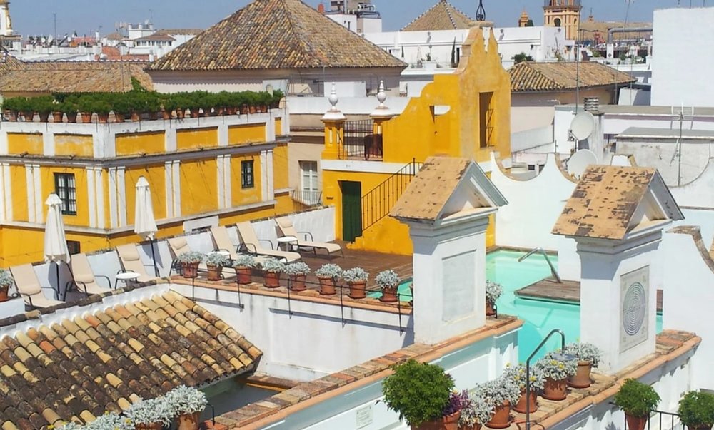 Rooftop terrace at Las Casas de la Judería with pool and views of Seville’s historic buildings