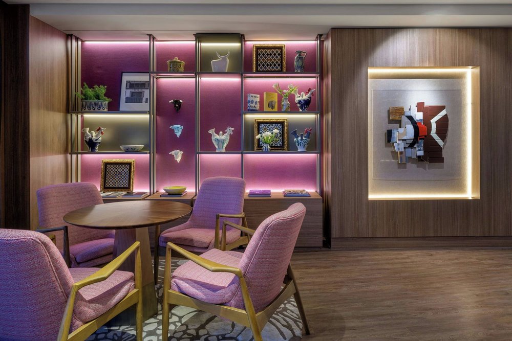 Stylish lounge area of Querencia de Sevilla Autograph Collection with wooden accents and softly lit display shelves