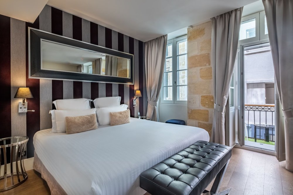 Modern guest room at Marty Hotel Bordeaux with minimalist decor and green accent wall
