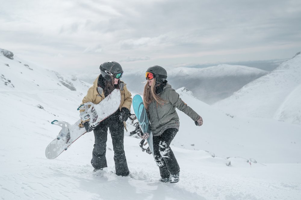 Two women snowboarding in Queenstown.