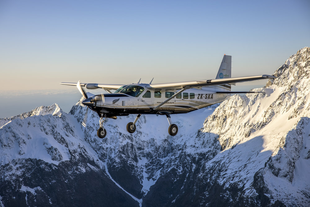 A small plane flying above Milford sound.