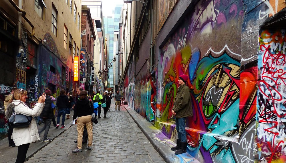 Colorful street art tucked inside Melbourne’s Hosier Lane | Photo from Bernard Spragg on Wikimedia Commons