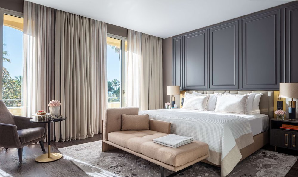 A bright, modern hotel room at Anantara Plaza Nice Hotel with large windows overlooking the sea