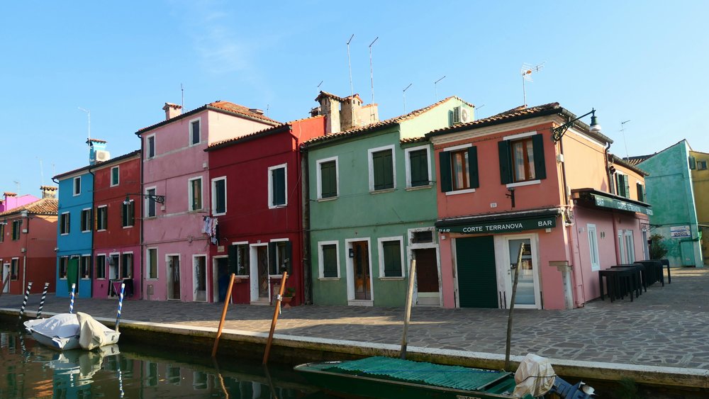 Colorful houses lining a canal in Burano, Venice | Photo Credits: Lukas Lussi