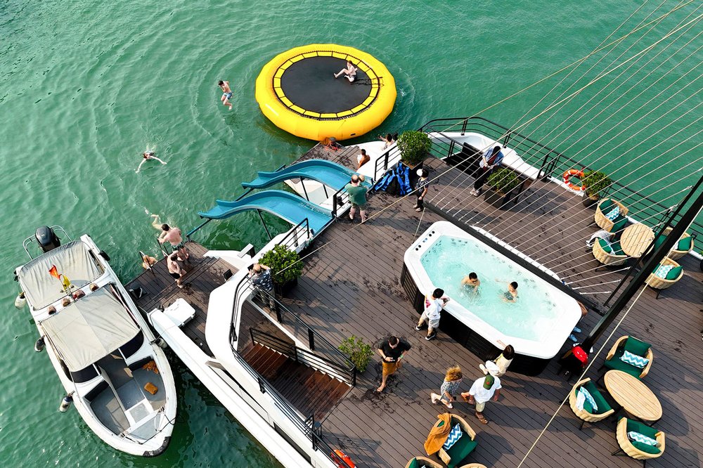 Travelers swimming, using water slides, and relaxing on a cruise deck in Halong Bay waters