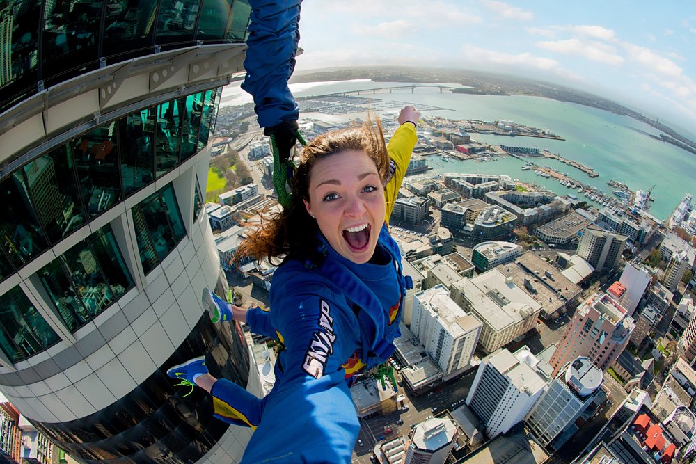 SkyWalk experience on Auckland Sky Tower edge with city views