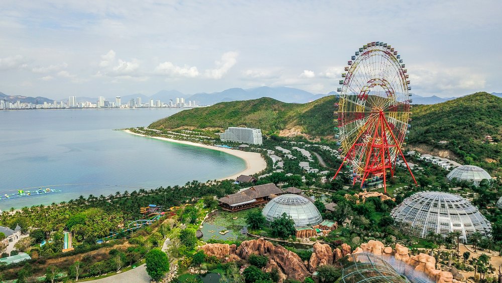 A sweeping view of the curved white-sand beach and turquoise water of Nha Trang, backed by resorts.