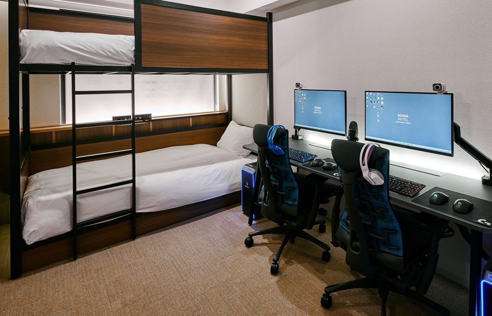 A bunk bed beside two gaming PC setup