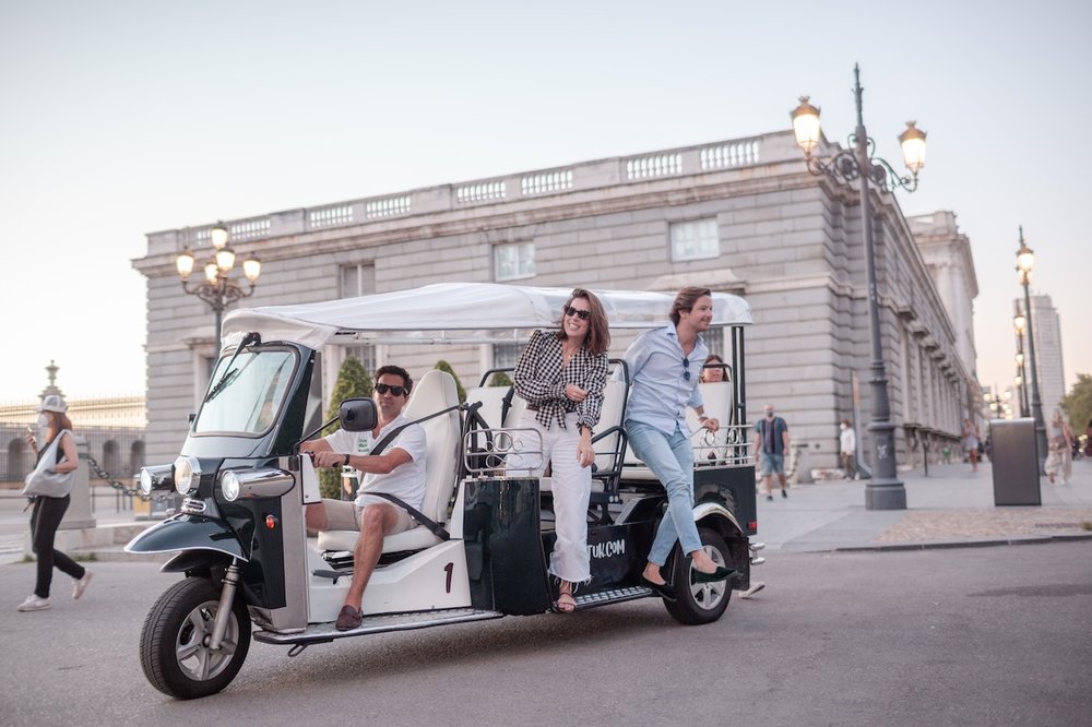 Travelers riding a tuk tuk during a sightseeing tour in Madrid