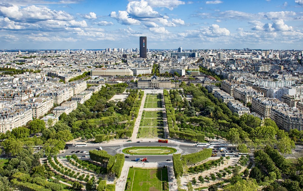 Aerial view of Paris with gardens, buildings, and skyline under blue skies