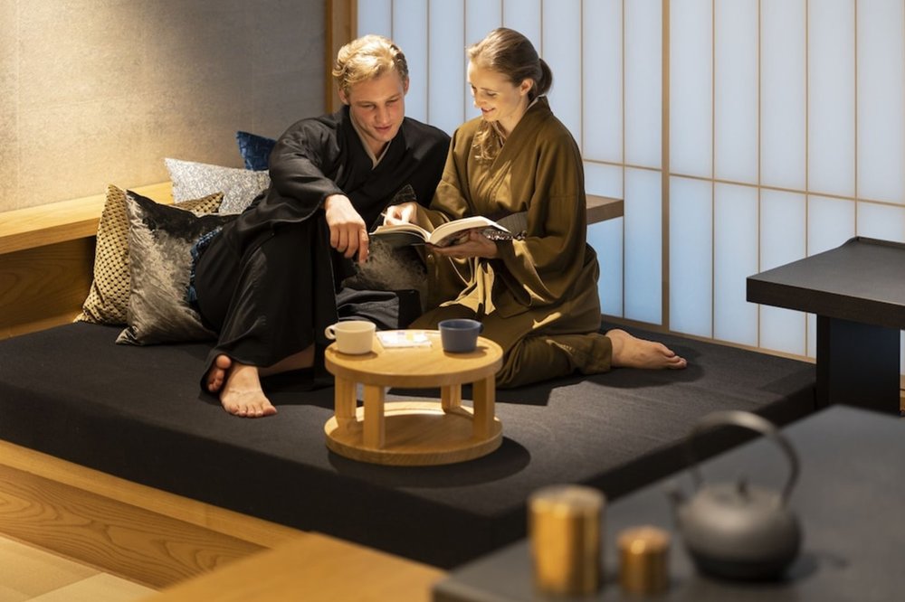 Two people relaxing inside a traditional Japanese hotel room at HOSHINOYA Tokyo.