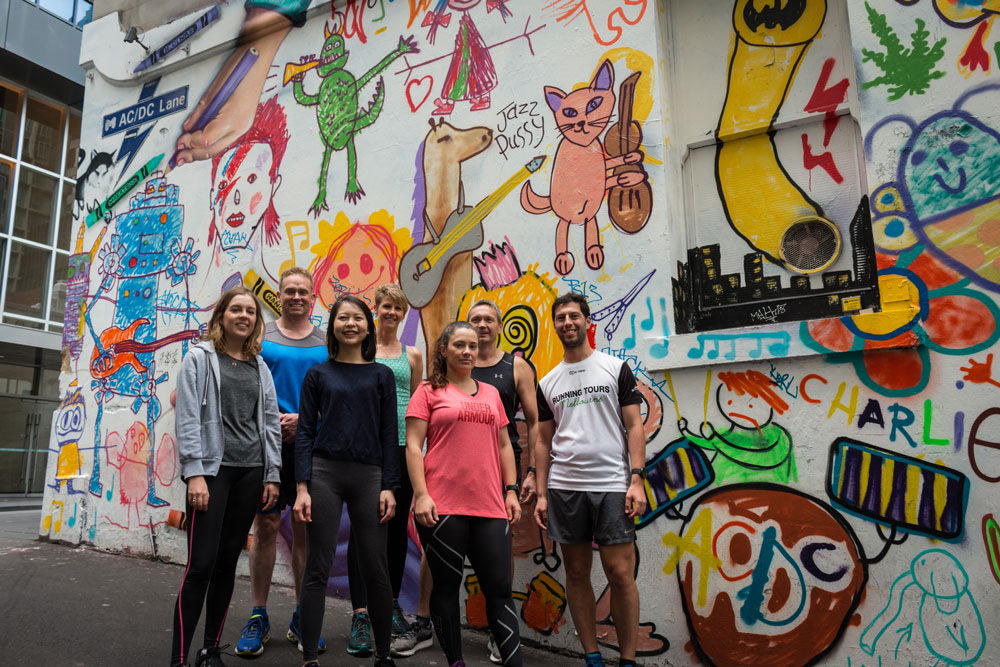 Group poses beside vibrant street art murals in Melbourne’s famous laneways
