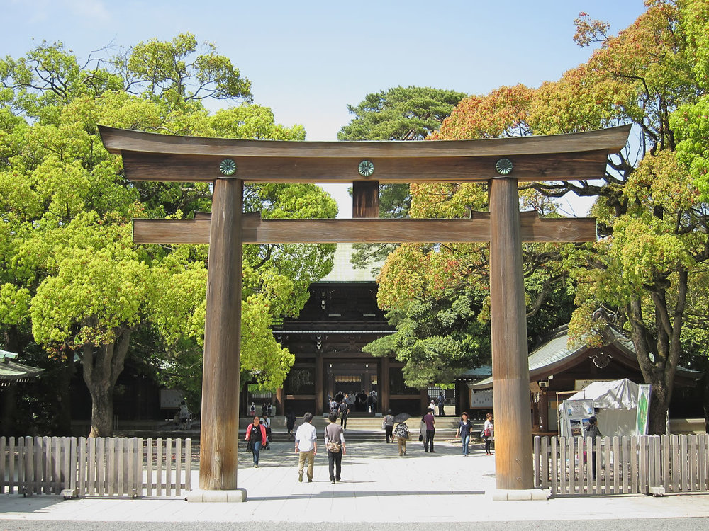 Visitors enter Meiji Shrine in Tokyo through a grand torii gate