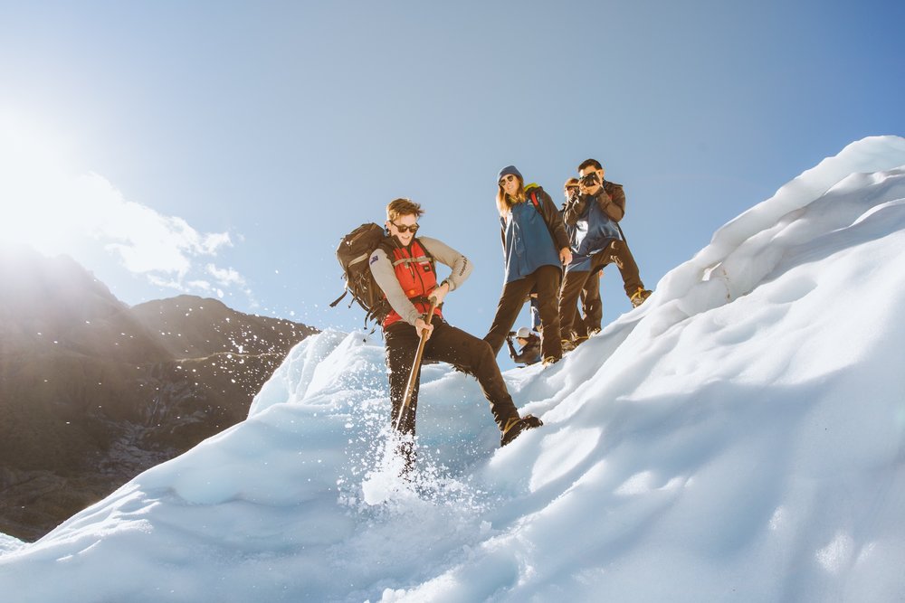A group of people hiking on ice at Fox Glacier.