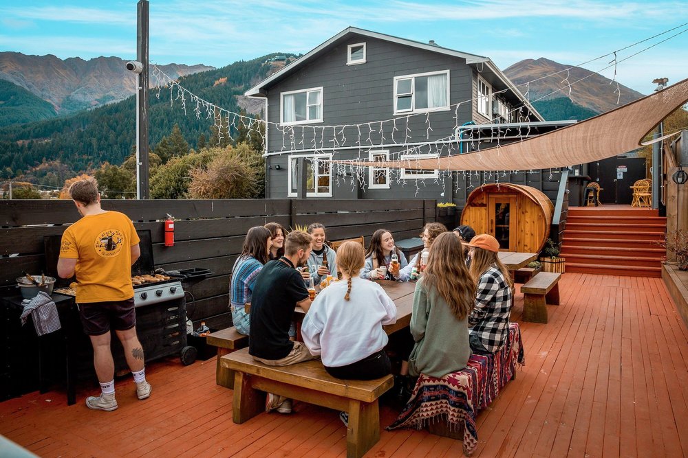 Guests enjoying dinner in backyard of The Black Sheep Backpackers