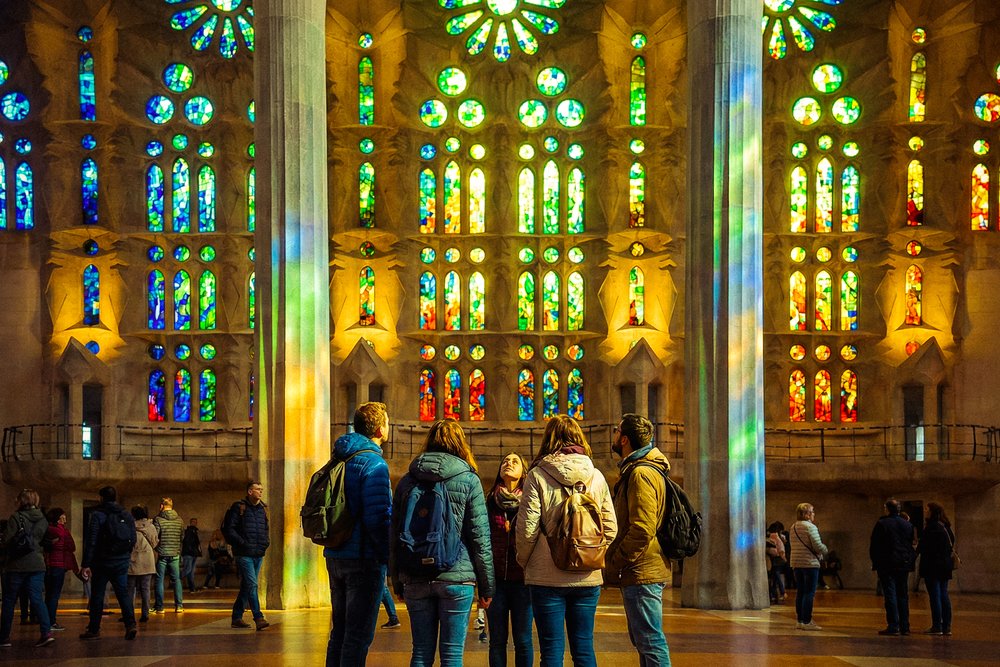Visitors admire the colorful stained-glass windows inside the Sagrada Família in Barcelona