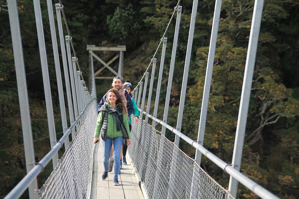 Hikers crossing the bridge in Rob Roy Glacier Track | Photo Credit: Flickr