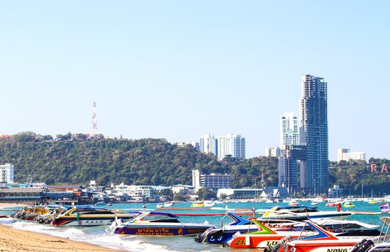 a beach in Thailand with a view of boats and buildings