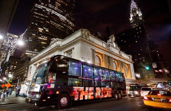the Ride NYC tour bus parked on a street in New York at night